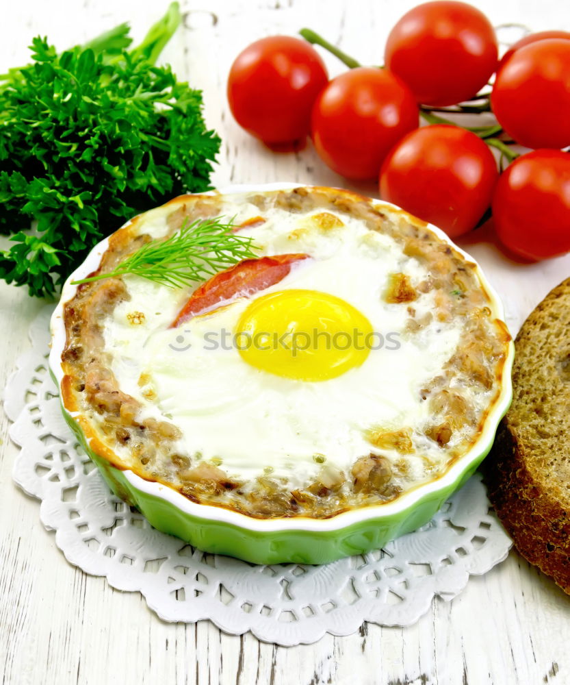 Fried egg with tomatoes and herbs on a old frying pan