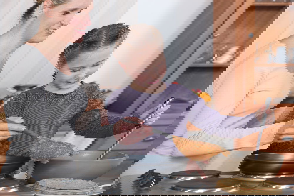 Similar – Image, Stock Photo Little sisters cooking with her mother in the kitchen.