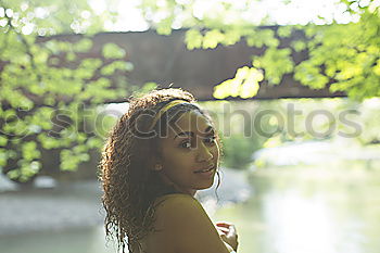 Happy young black woman sitting surrounded by flowers