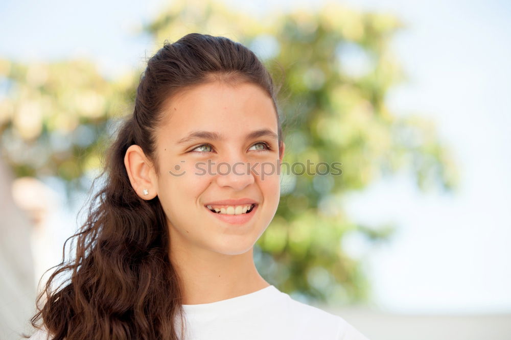 Close portrait of beautiful young woman with green eyes smiling at camera