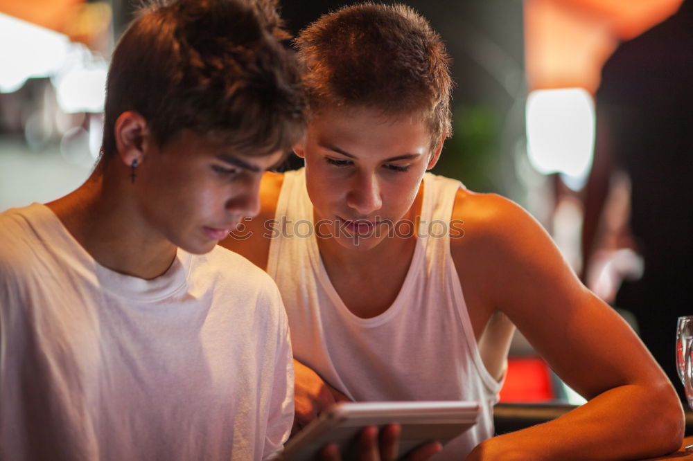 Image, Stock Photo Two teenagers in white sports shirts using tablet PC in cafeteria. They looking at pad screen