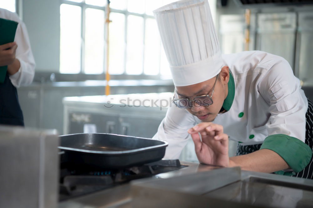 Similar – A cook in a restaurant wearing a mask as a precaution against the coronavirus preparing the meal.