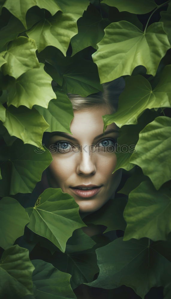 Similar – View through, portrait of young woman in dense vegetation