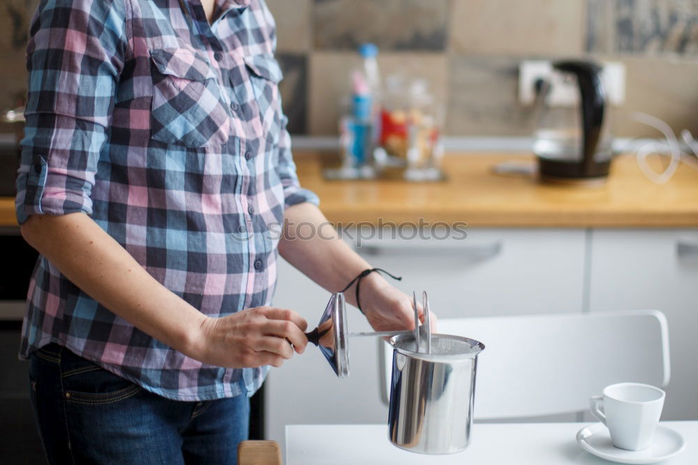 Hipster barista pours milk for making cappuccino or latte coffee in the cafe