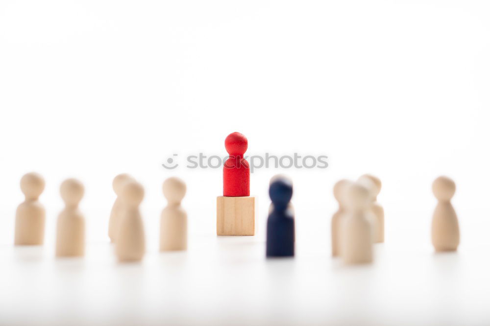 Similar – Single red toy figure in front of a row of black toy figures