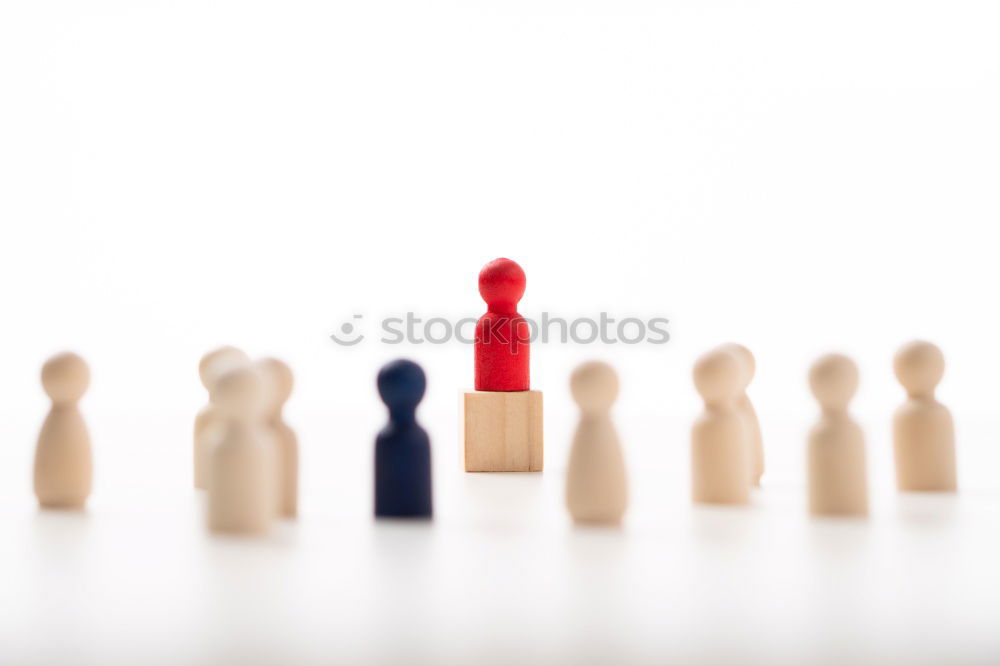 Similar – Single red toy figure in front of a row of black toy figures