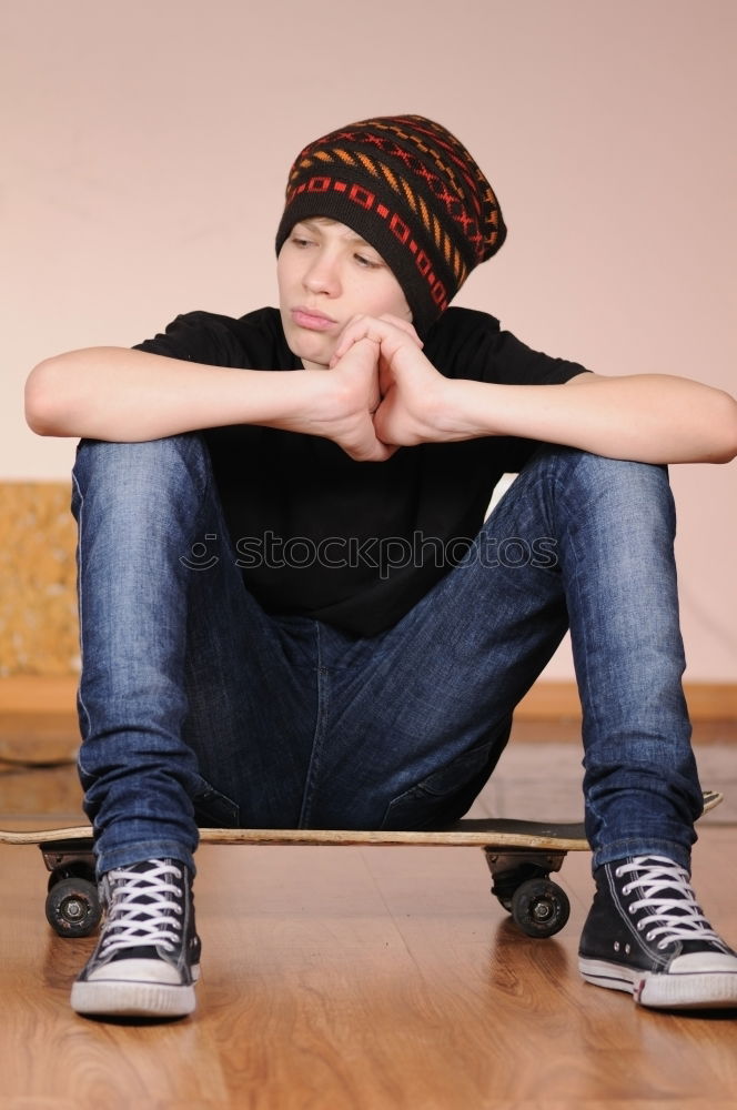 Similar – Image, Stock Photo Front view of young boy sitting on ground leaning on a yellow wall while using a mobile phone to listening music