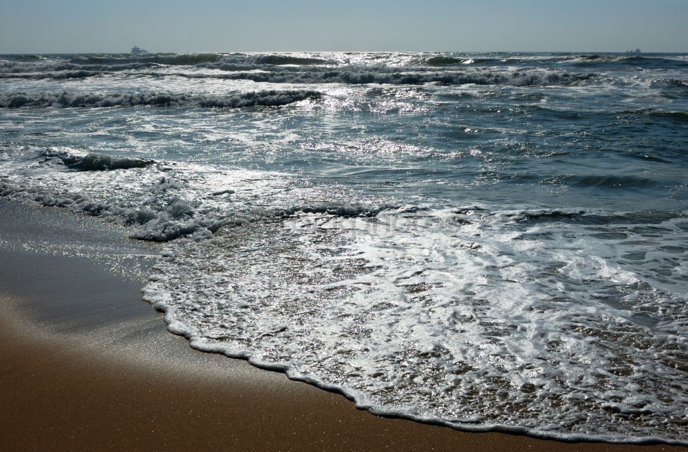 Steg mit Sonnenschutzdach am Strand bei stürmischer See