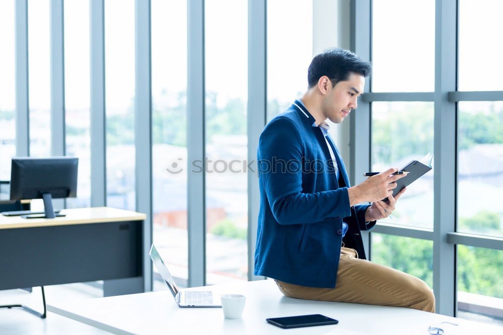 Similar – Geschäftsmann mit Blick auf das Smartphone im modernen Firmenbüro.