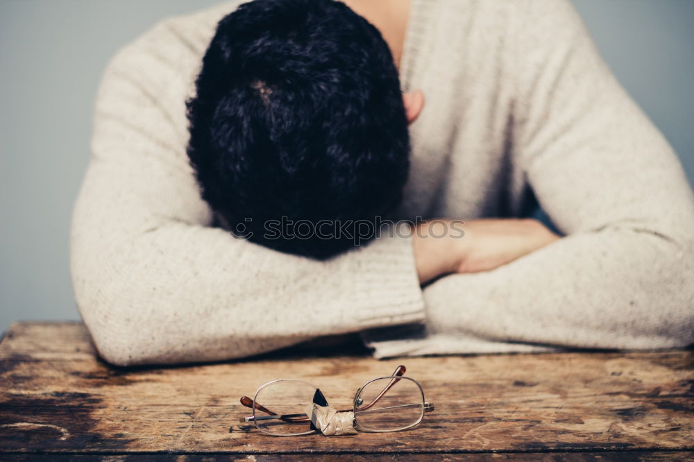 Similar – one sad woman sitting near a wall and holding her head in her hands