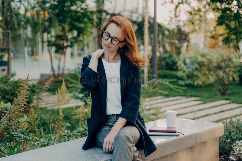 Similar – two women friends sitting down at stairs outdoors using laptop