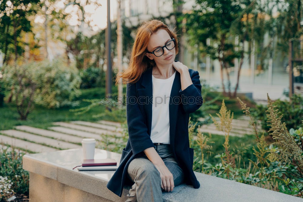 Similar – Young woman sitting leaning against a wall in the shade