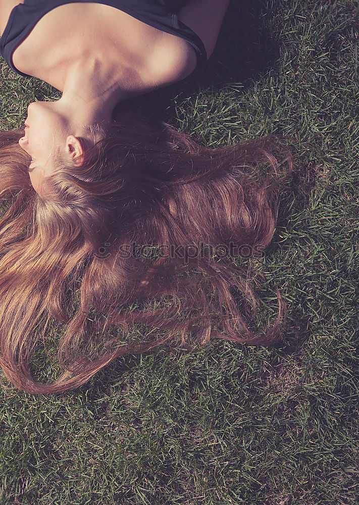 Similar – smiling portrait of a beautiful young sexy redhead woman spreading red hair fan-shaped lying relaxing on the green grass, upside down, copy space