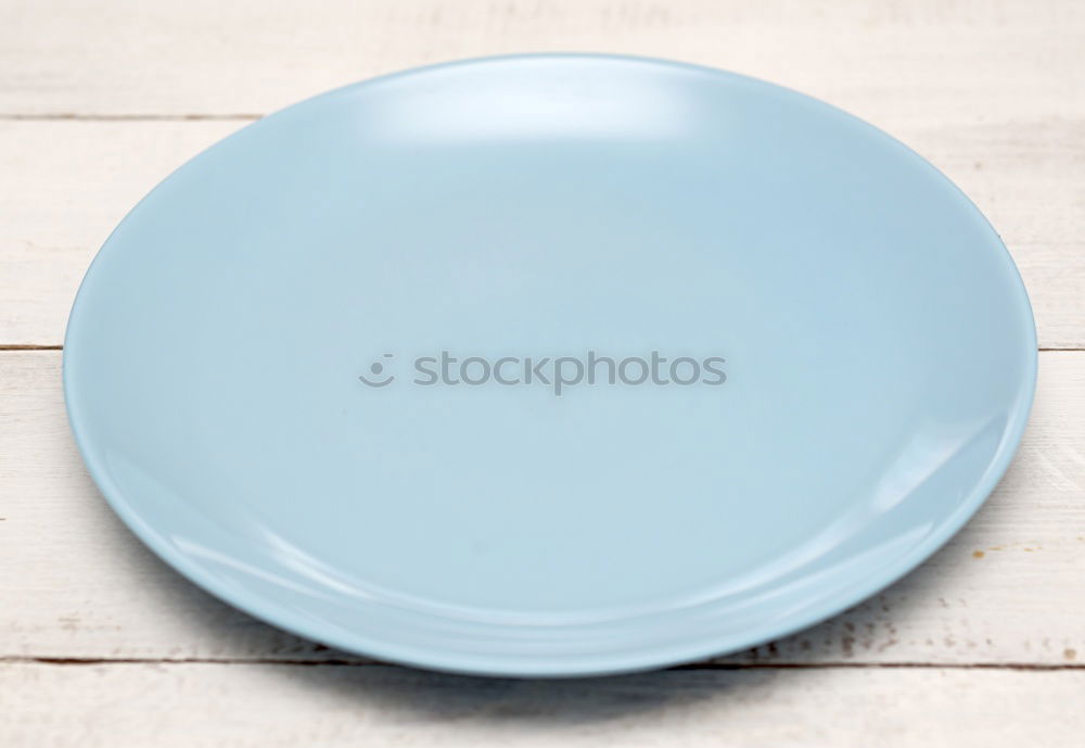 Empty plate on blue wood background