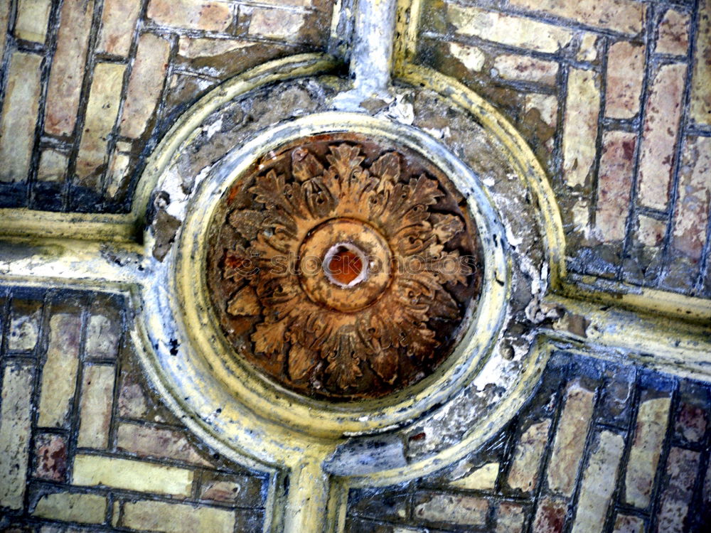 Gully cover with embedded cobblestones with grey paving stones arranged in a circle in pouring rain