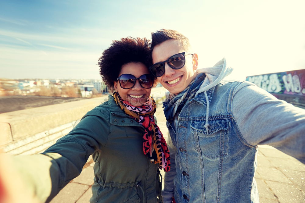 Similar – Interracial young couple taking pictures to each other and having fun