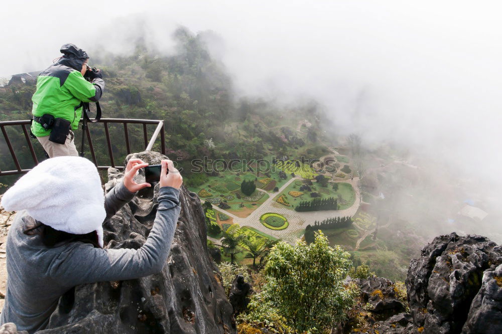 Similar – Young woman with hiking backpack stands on the edge of rain covered valley