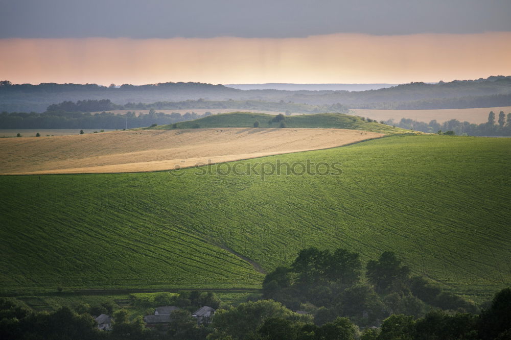 Similar – Fields and buildings in the mist at sunset.