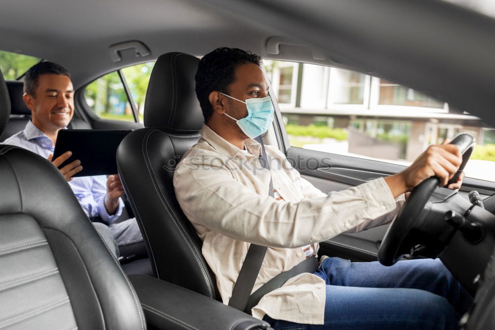 Taxi driver in a mask with a client on the back seat wearing mask