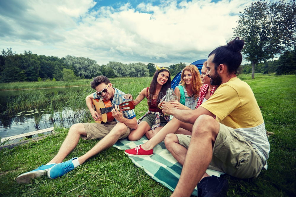 Family spending vacation time together having a snack sitting on jetty over the lake on sunny day in the summertime