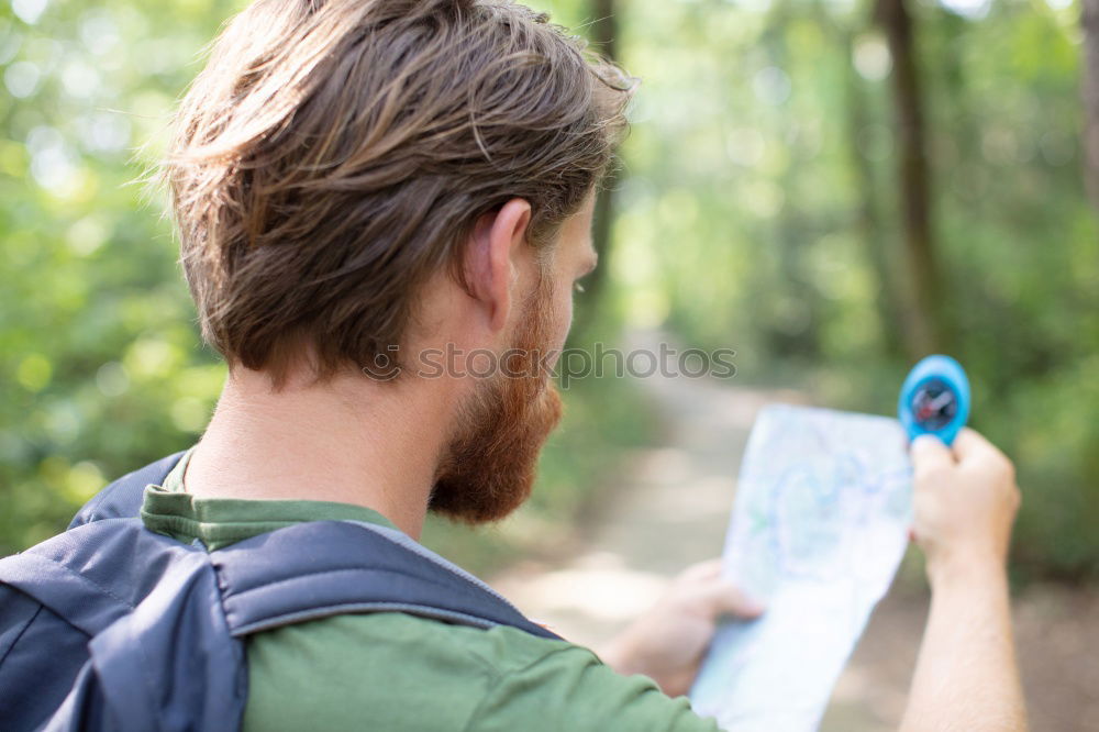 Similar – Man navigating on road in woods