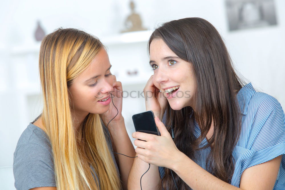 Similar – Image, Stock Photo Young women using mobile phones watching music clip, texting, messaging. Teenagers using the smartphones, sitting on sofa at home. Using technology devices. Girls wearing summer clothing