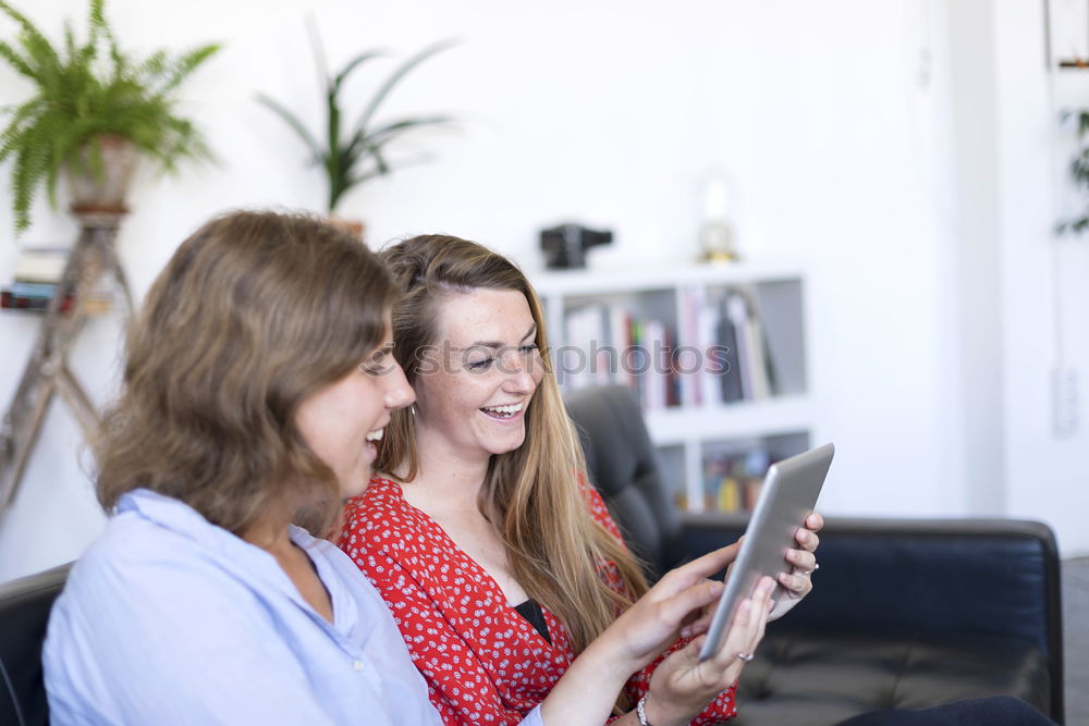 Similar – Image, Stock Photo Overhead photograph of two beautiful young women at home sitting on sofa while using a tablet PC computer and smiling