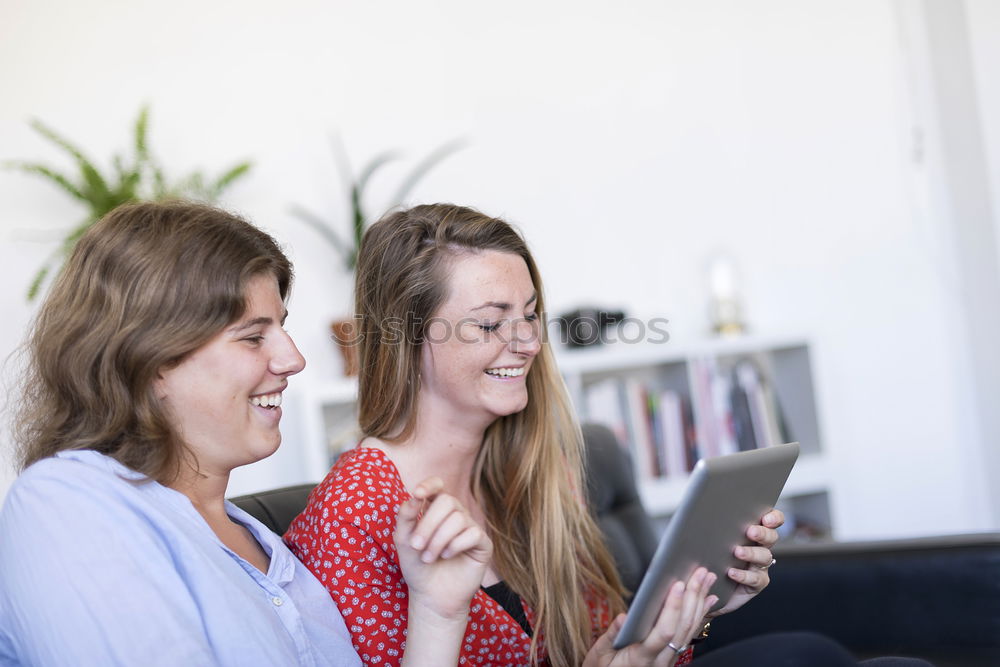Similar – Image, Stock Photo Overhead photograph of two beautiful young women at home sitting on sofa while using a tablet PC computer and smiling
