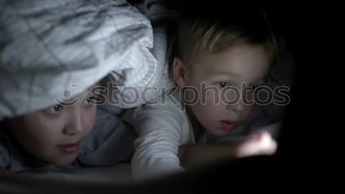 Similar – Image, Stock Photo Kids sitting on the bed looking tablet in the dark