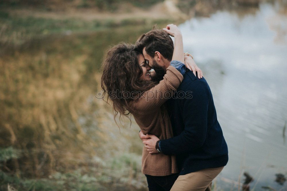 Close up of bearded man and blonde woman hugging outdoors