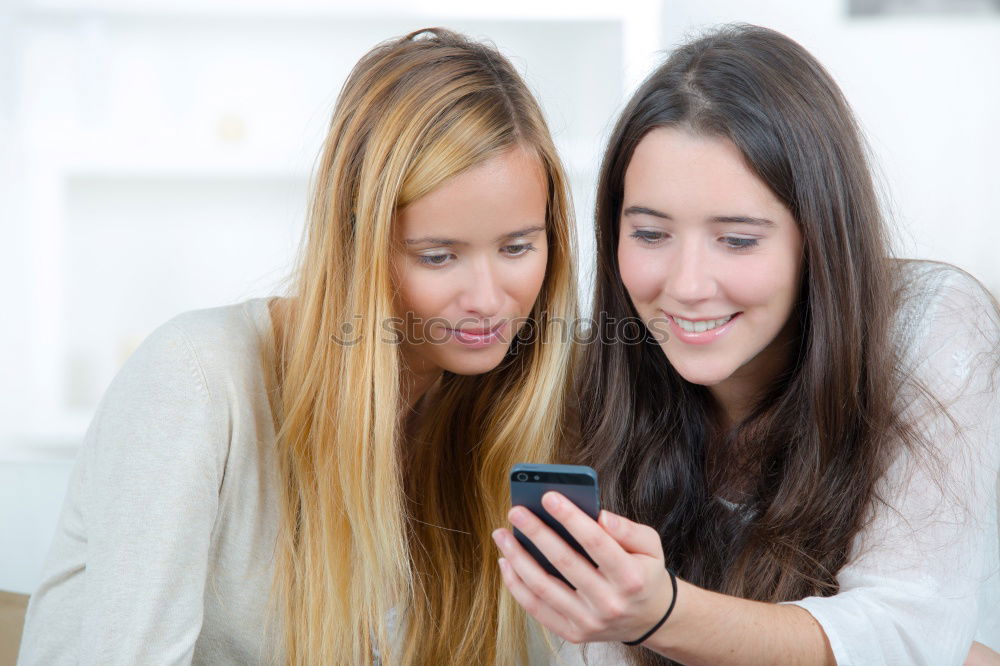 Similar – Image, Stock Photo Young women using mobile phones watching music clip, texting, messaging. Teenagers using the smartphones, sitting on sofa at home. Using technology devices. Girls wearing summer clothing