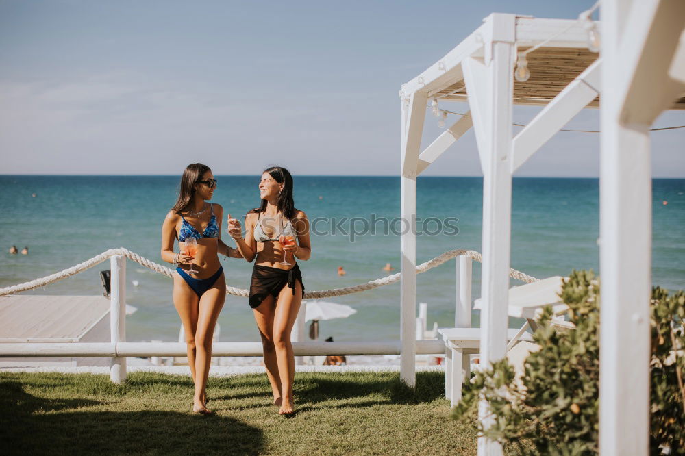 Smiling young women in bikini enjoying vacation on the beach