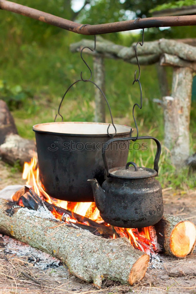 Similar – Image, Stock Photo Goulash beeing cooked in a cauldron over an open fire on a picnic.