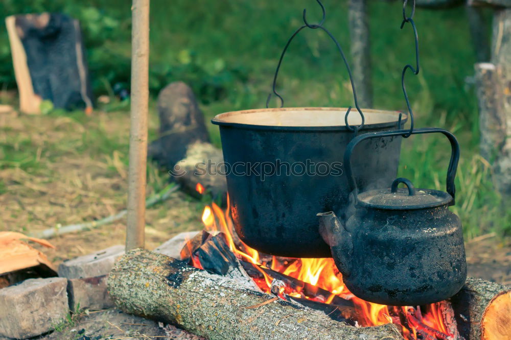 Similar – Image, Stock Photo Goulash beeing cooked in a cauldron over an open fire on a picnic.