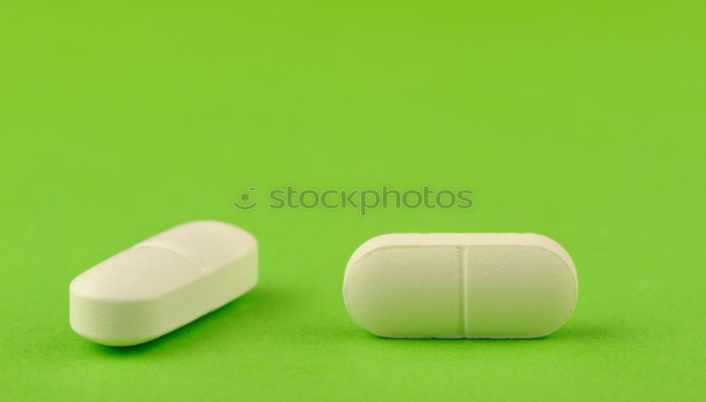 Similar – white plastic can and scattered oval pills