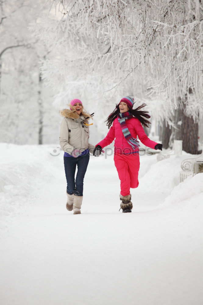 Similar – Family, mother and two daughters, spending time together walking outdoors in winter. Woman is pulling sled with her little daughter, a few years old girl, through forest covered by snow while snow falling, enjoying wintertime. Mother is wearing red winter