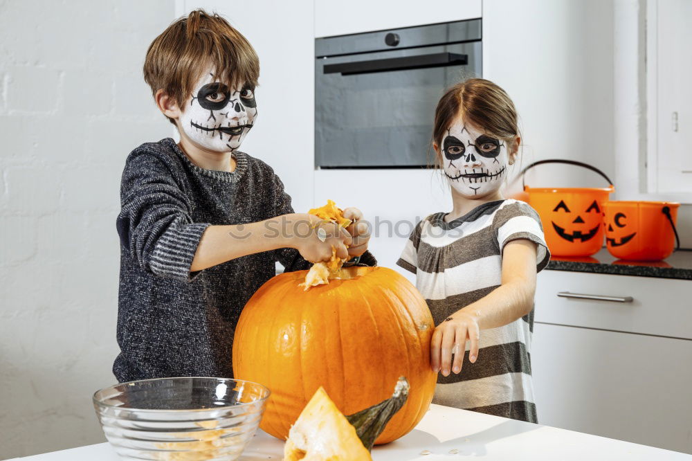 Similar – Image, Stock Photo Happy children disguised decorating a pumpkin at home.