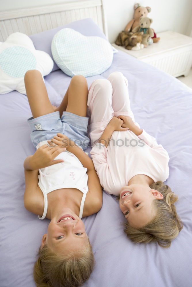 Similar – Two beautiful sisters playing on bed