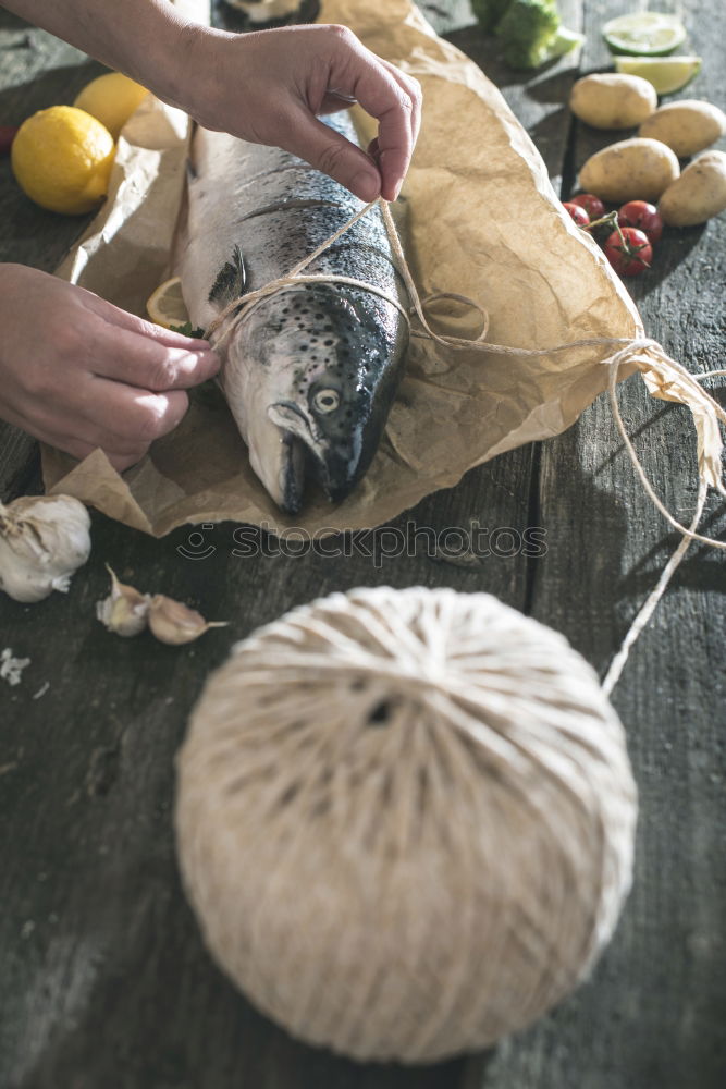 Tying a rope on fish for grilling