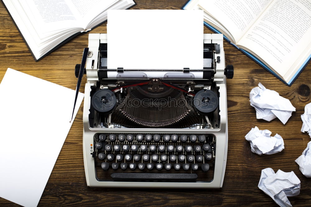 Text prescribed on a vintage typewriter and watch timekeeper.