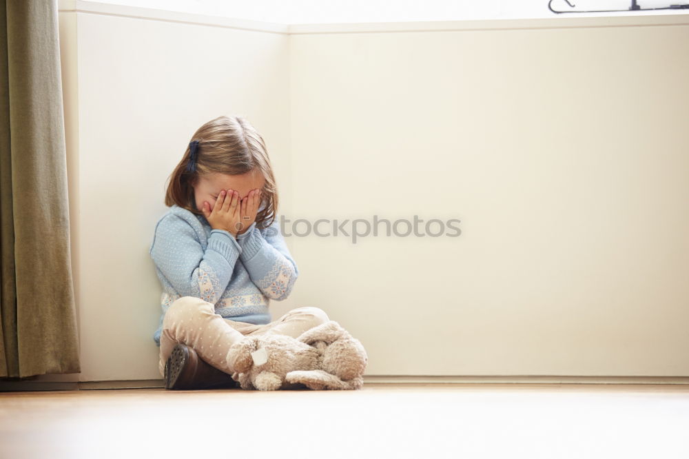 Similar – sad little girl sitting near the wall