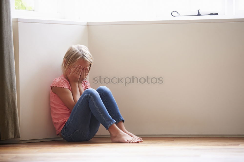 Similar – sad little girl sitting near the wall