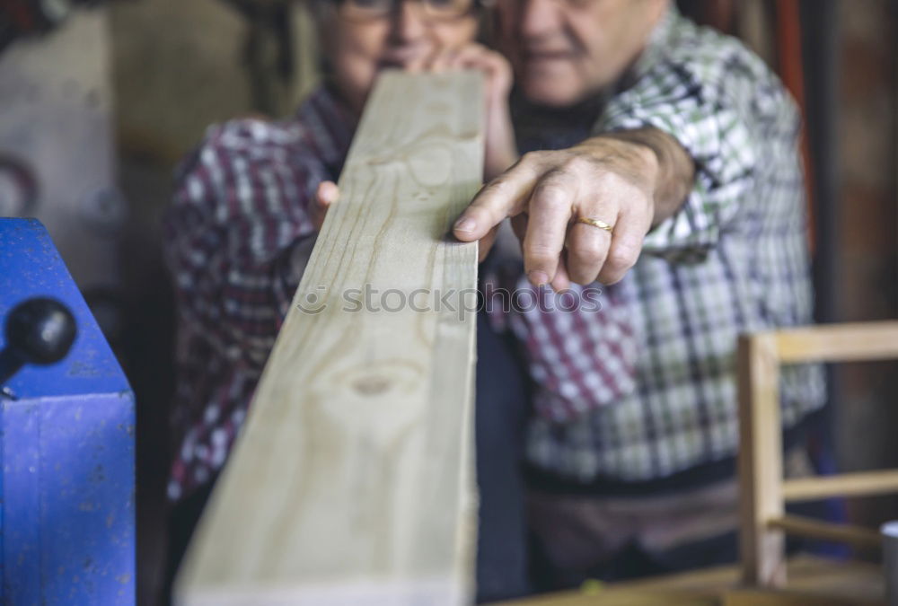 Professional carpenter cutting wooden board at his workshop