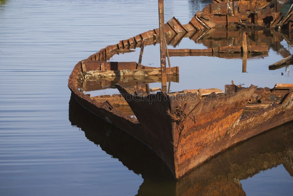 Similar – Spiegelung der Unterseite eines Fischerbootes im Abendlicht