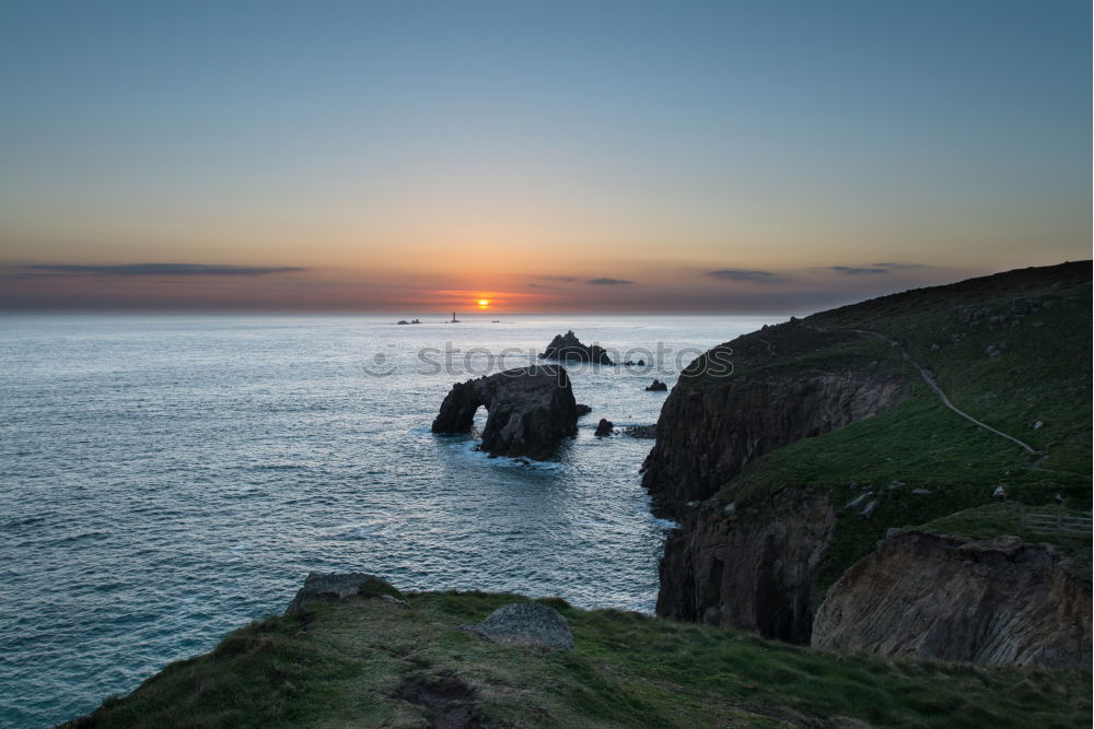 Similar – Felsenküste mit Leuchtturm in der Abenddämmerung