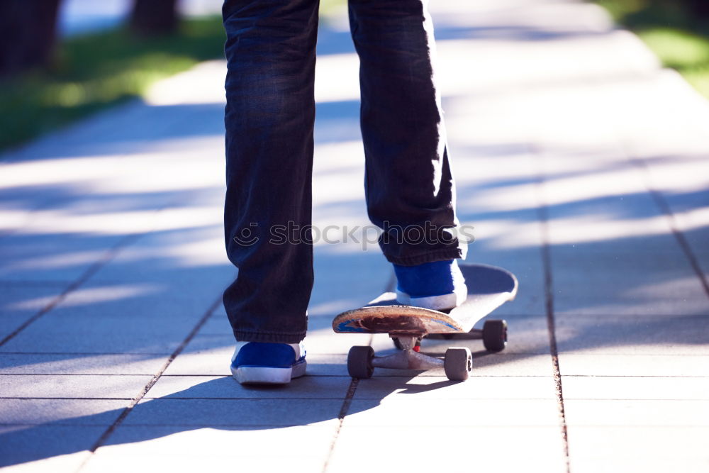 Similar – Ein junger Mann steht, während er seinen Fuß auf einem Skateboard hält.