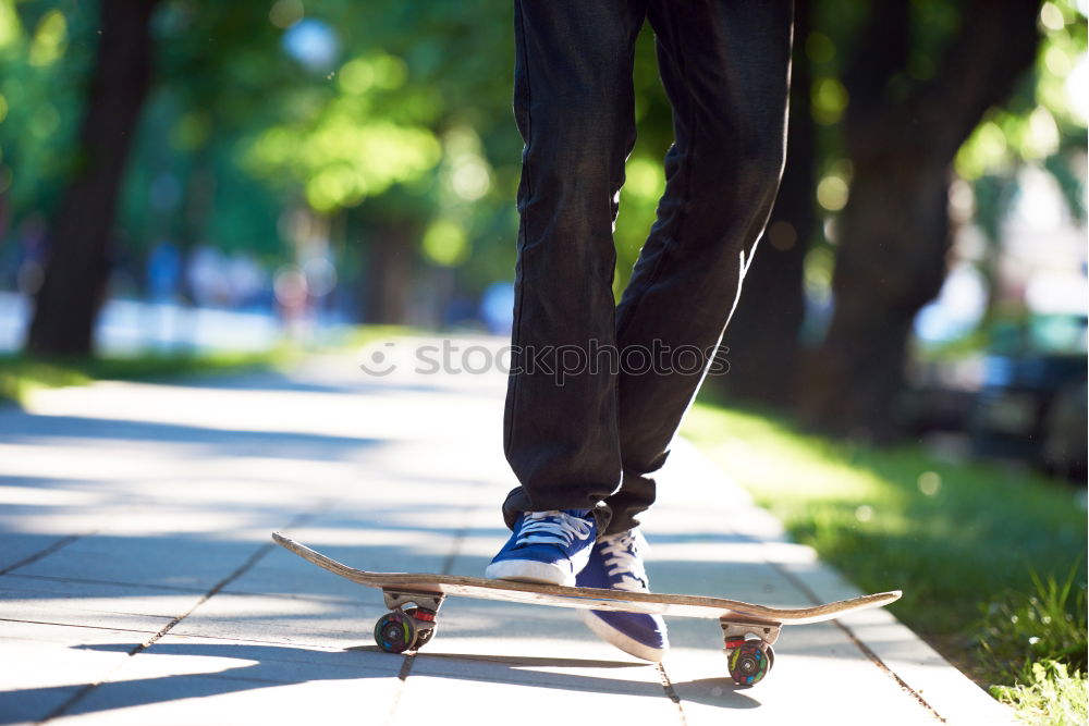 Similar – Ein junger Mann steht, während er seinen Fuß auf einem Skateboard hält.