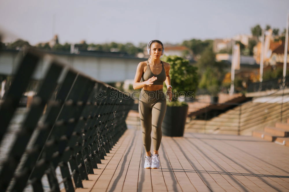 Similar – Young fitnesswoman runner stretching legs after run.