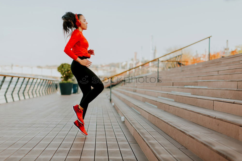 Young fitness woman runner running on city bridge.