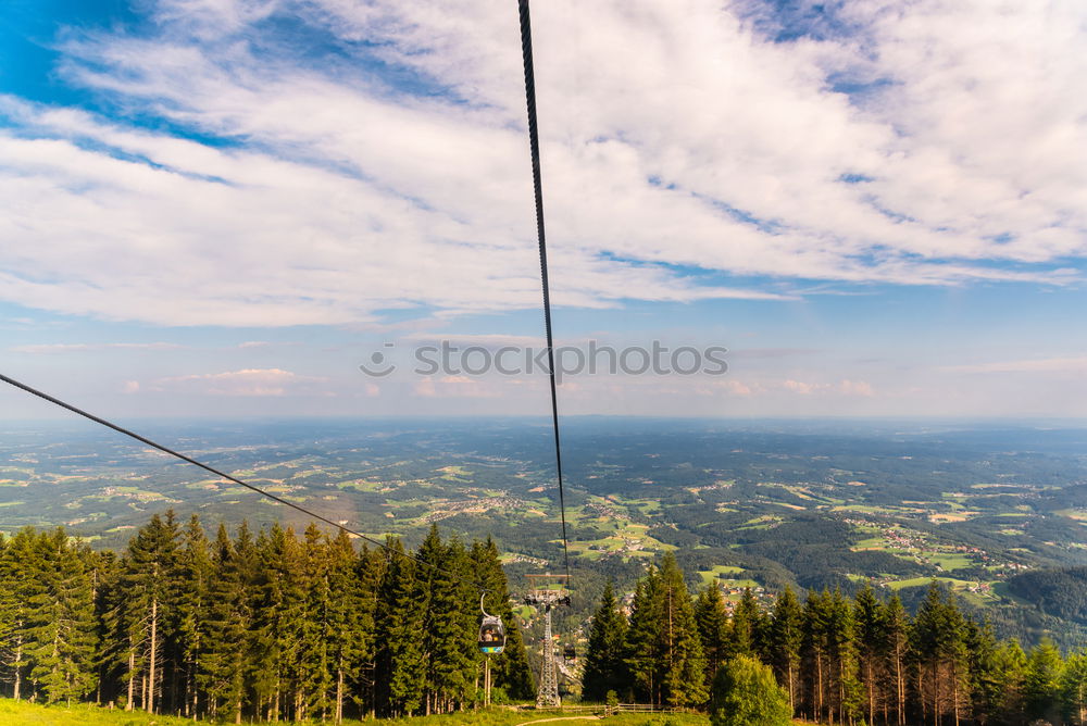 Similar – Chairlift with empty 2-seater chair and view of snow-free hill country